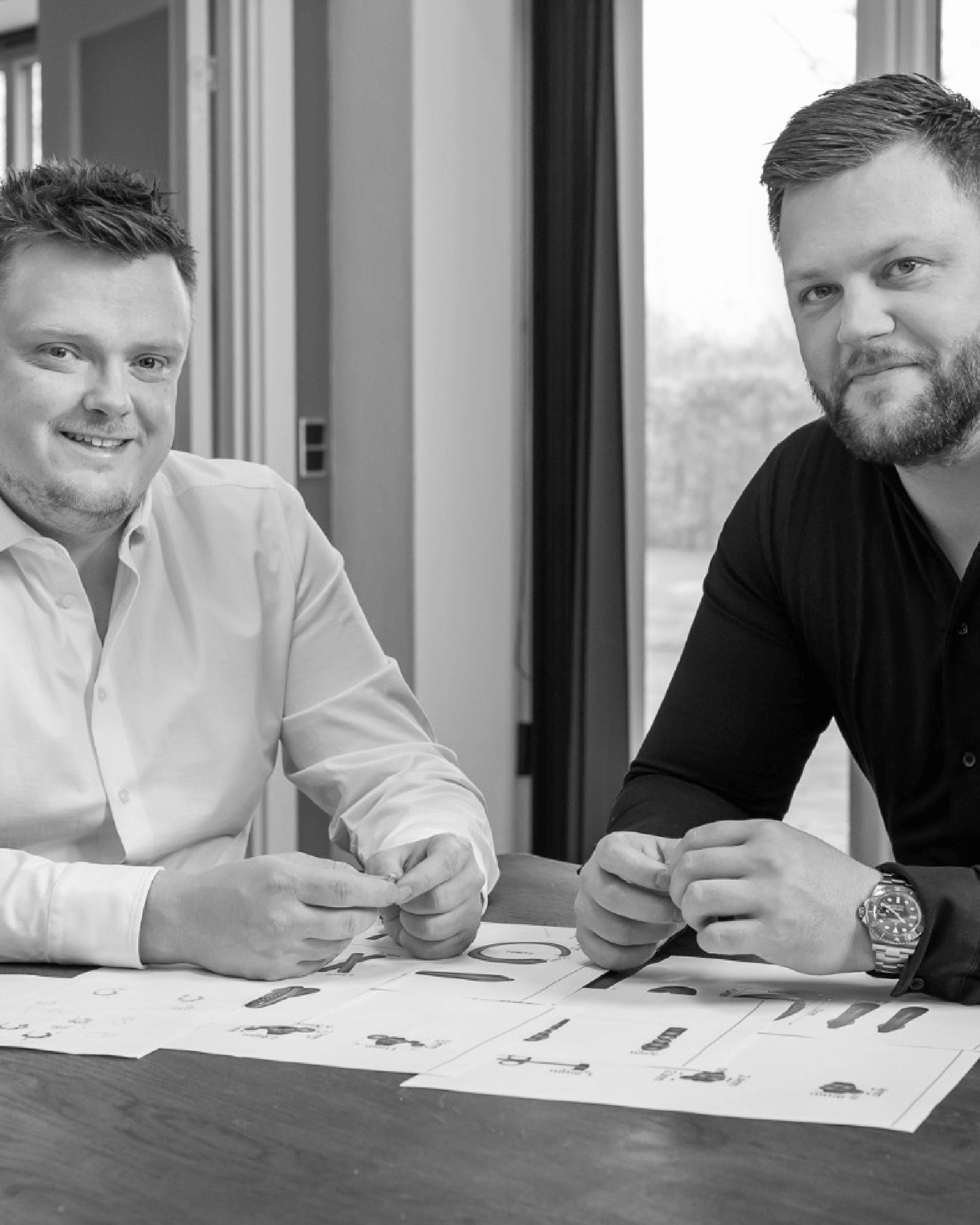 Lemores stiftere sidder ved et bord og gennemgår tegninger og designs i et arbejdsrum.