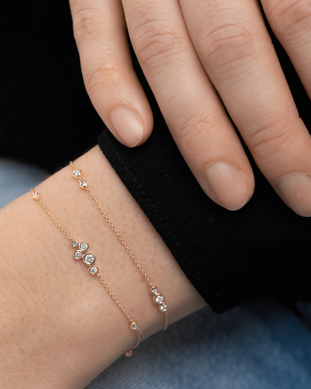 Model med to Eclipse armbånd i 14 kt guld med laboratorieskabte diamanter.