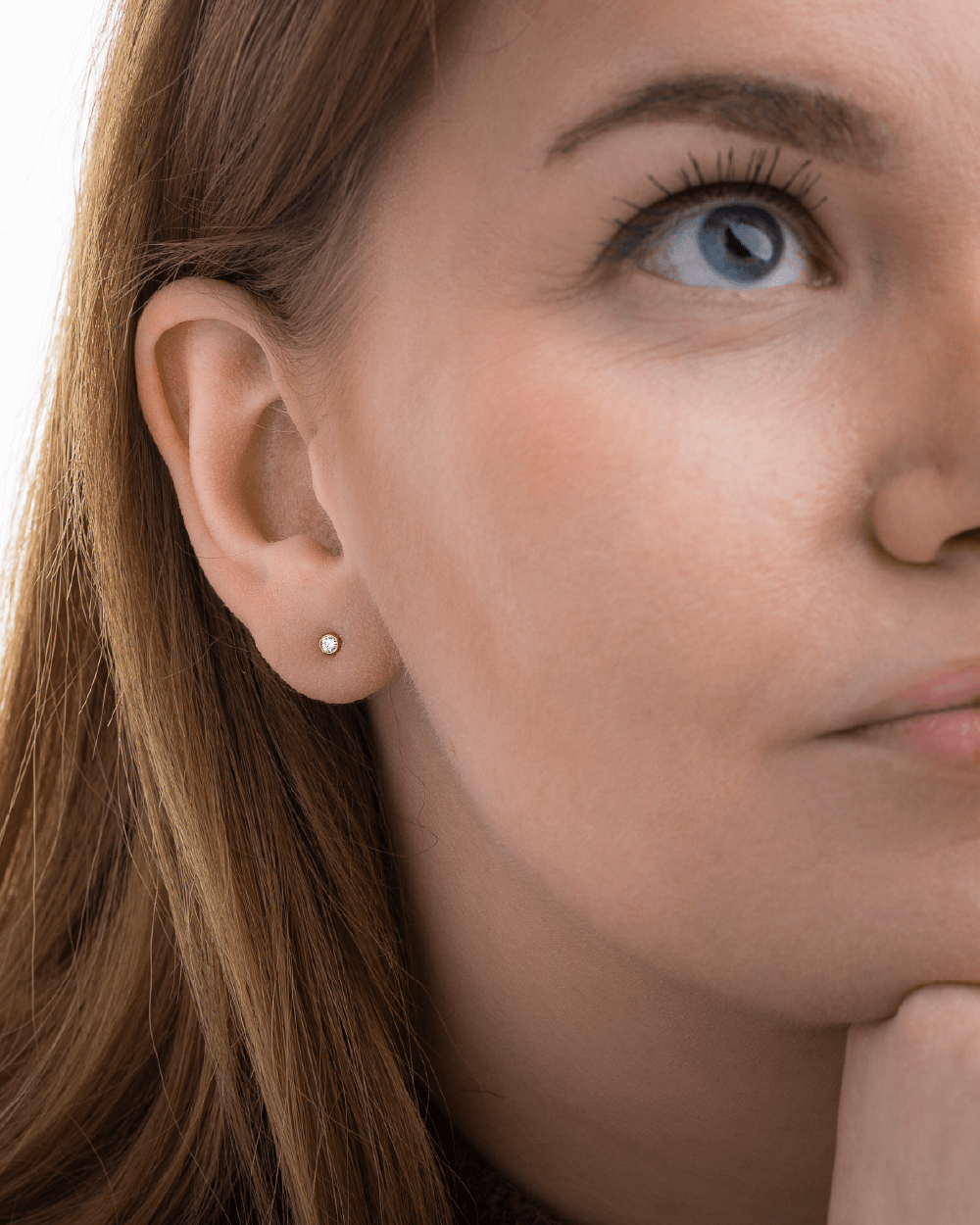 Model med Eclipse solitaire ørestik i 14 kt guld med laboratorieskabt diamant.