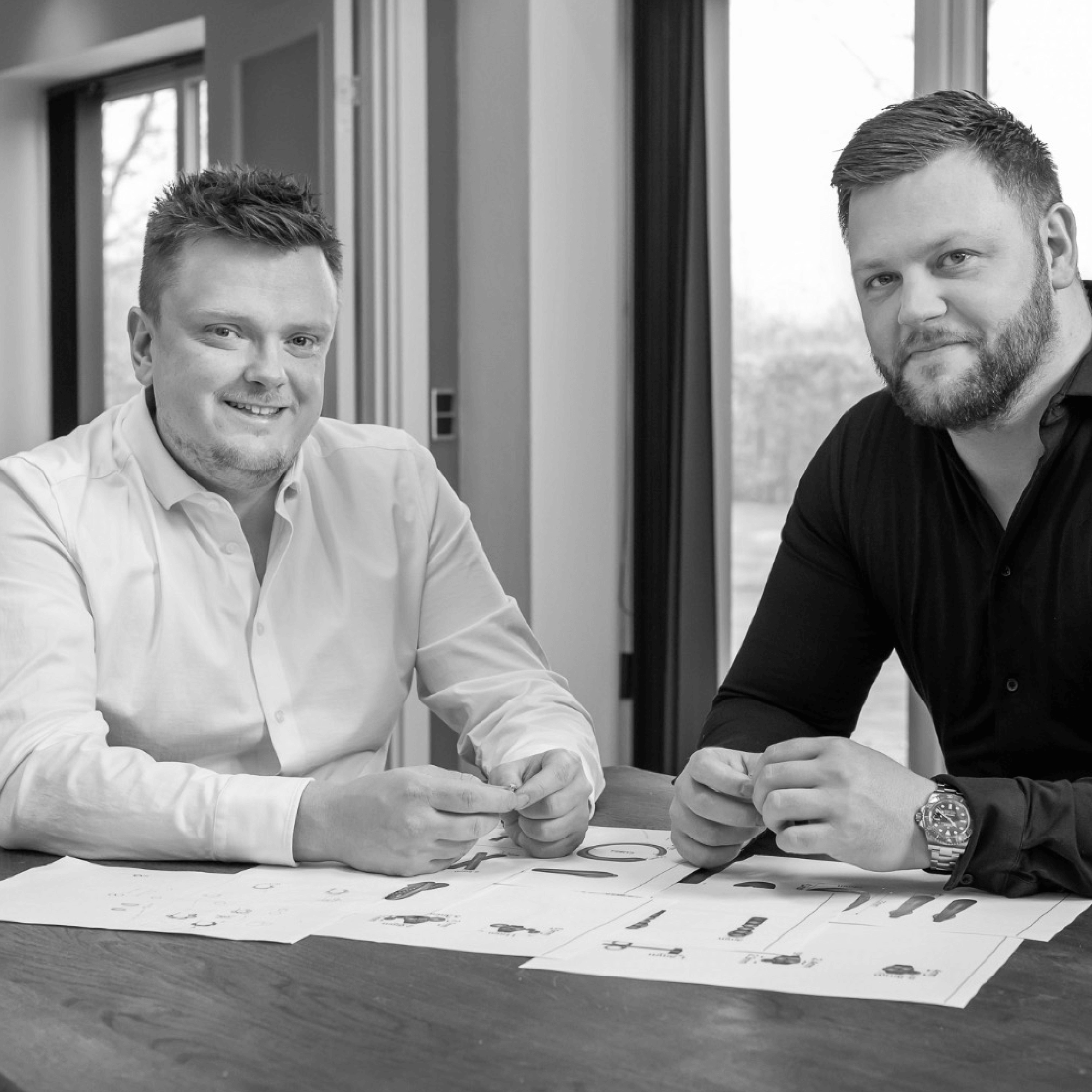 Lemores stiftere sidder ved et bord og gennemgår tegninger og designs i et arbejdsrum.