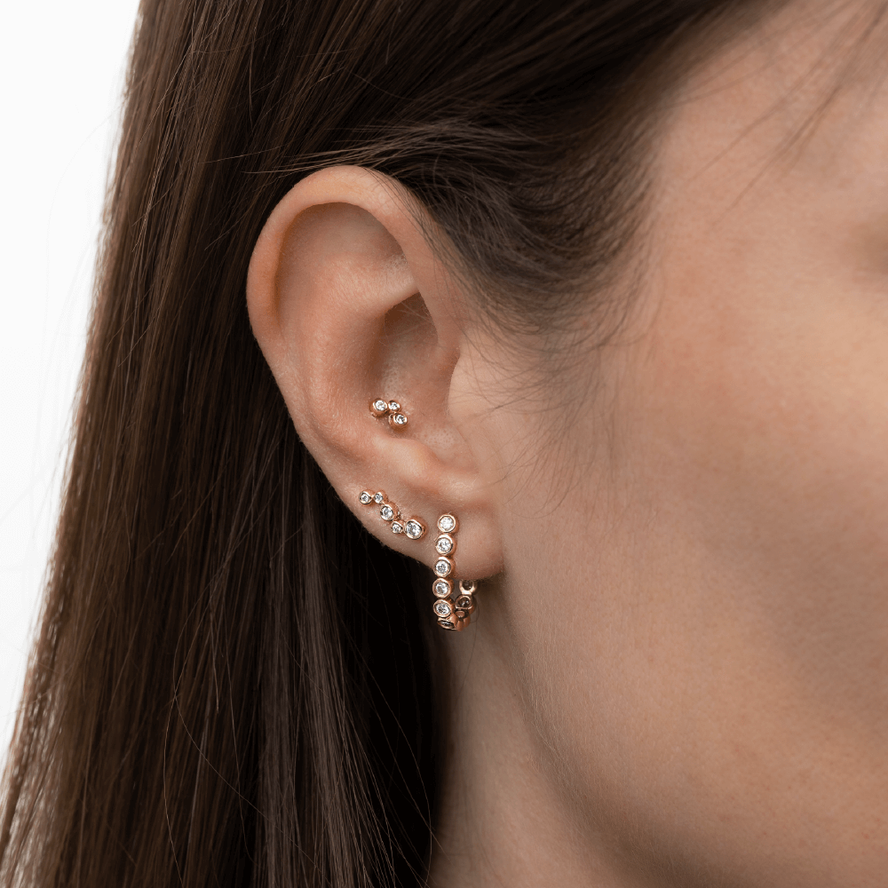 Model med flere Eclipse øreringe i 14 kt guld med laboratorieskabte diamanter.