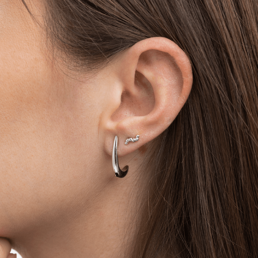 Model med Serene ørering i sterlingsølv kombineret med Orbis mini ørestikker i sterlingsølv.