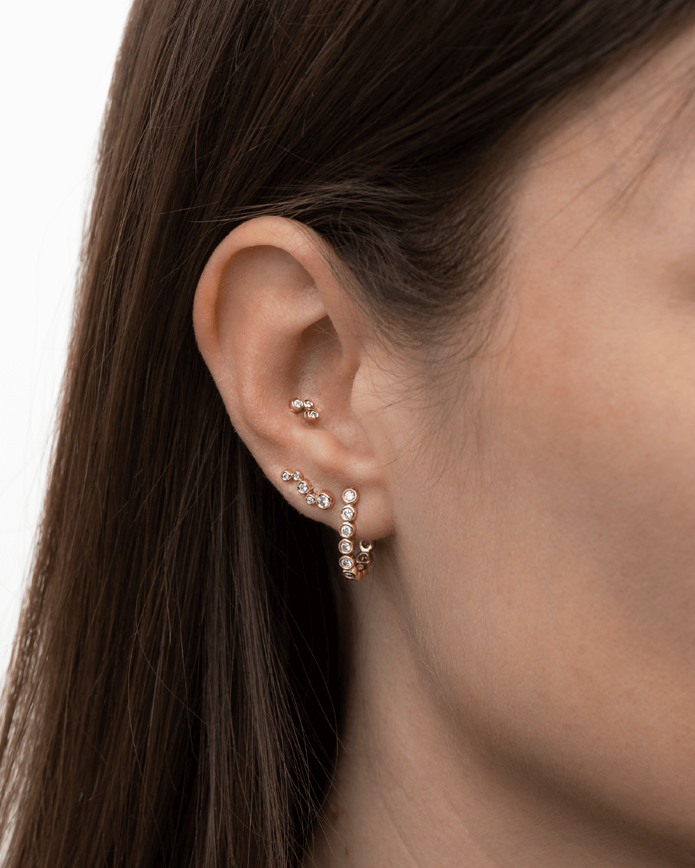 Model med flere Eclipse øreringe i 14 kt guld med laboratorieskabte diamanter.