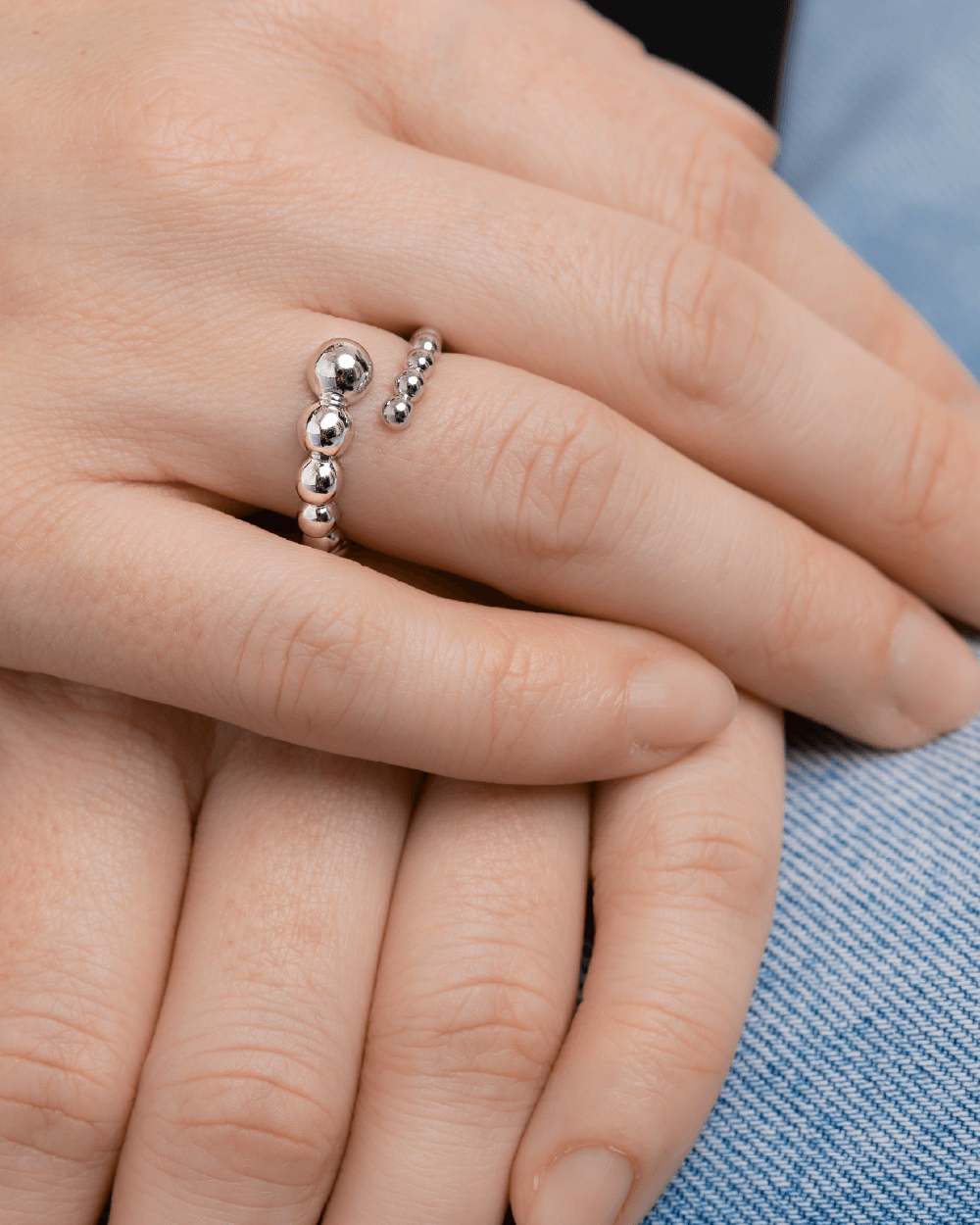 Nærbillede af Orbis ring i sterlingsølv med polerede kugler på modelhånd.