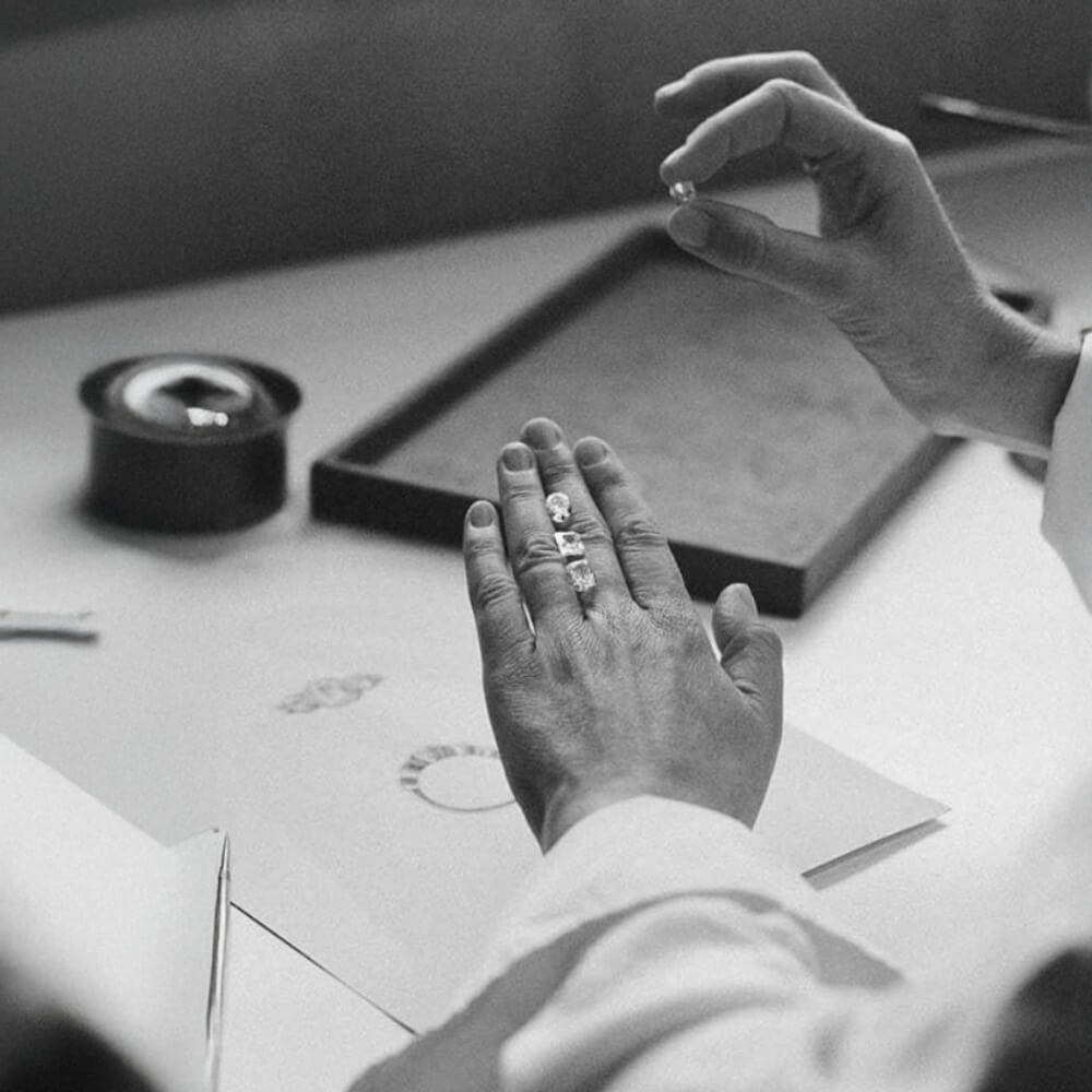 Billede af diamanter der inspiceres i hænder ved et arbejdsbord