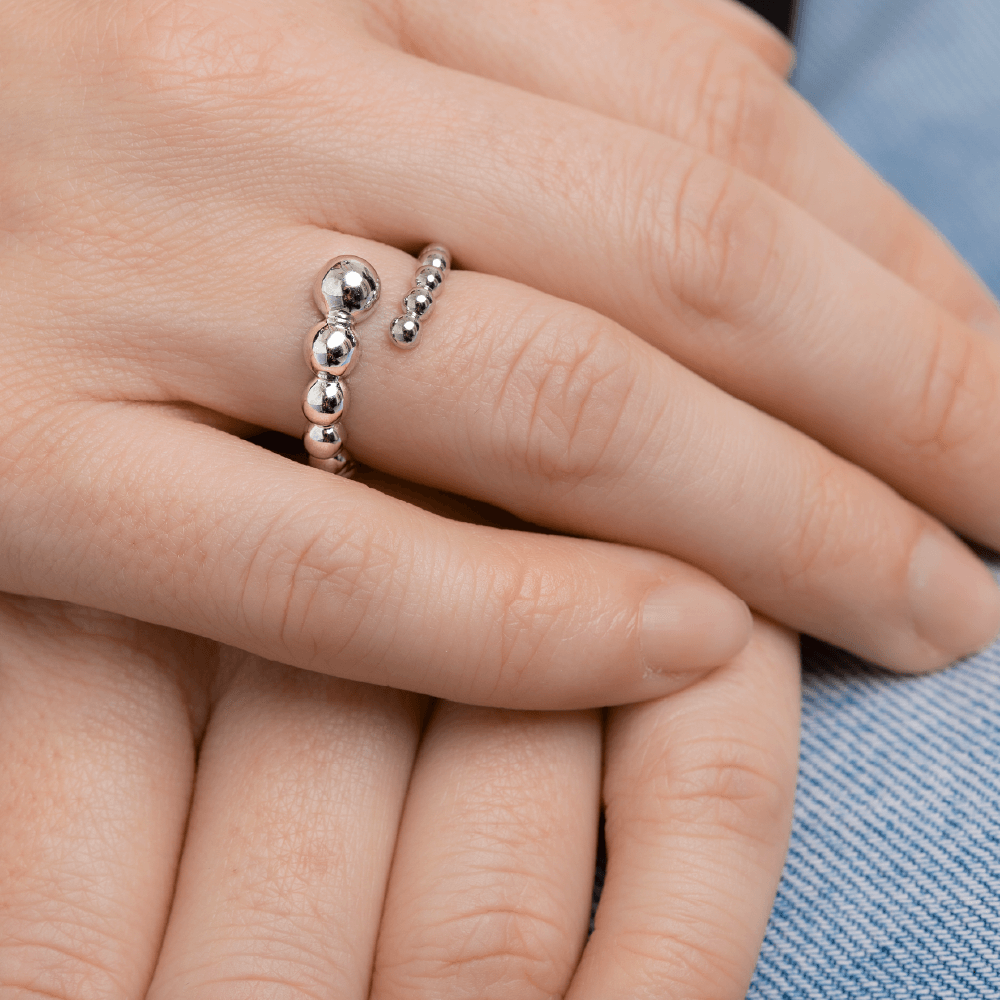 Nærbillede af Orbis ring i sterlingsølv med polerede kugler på modelhånd.