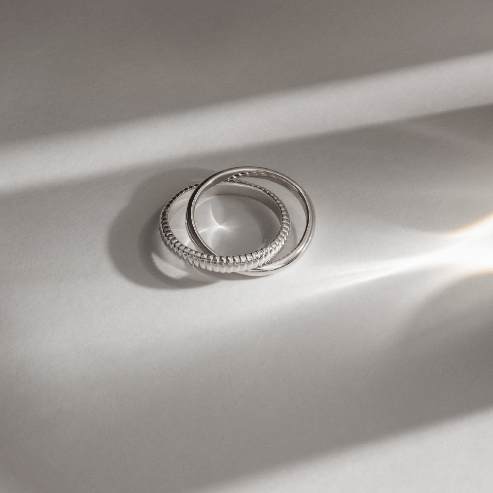 Softpack foto med en Orbis ring i sterlingsølv på lys baggund med lysreflektioner.