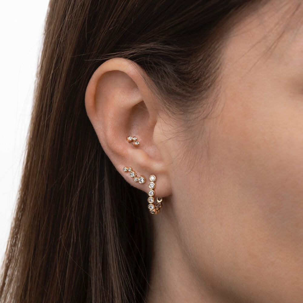 Model med flere Eclipse øreringe i 14 kt guld med laboratorieskabte diamanter.
